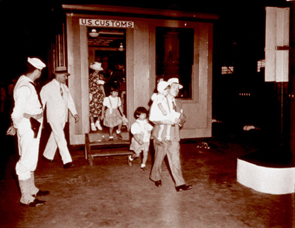 A Japanese family walking out of a U.S. customs booth, ca. 1943